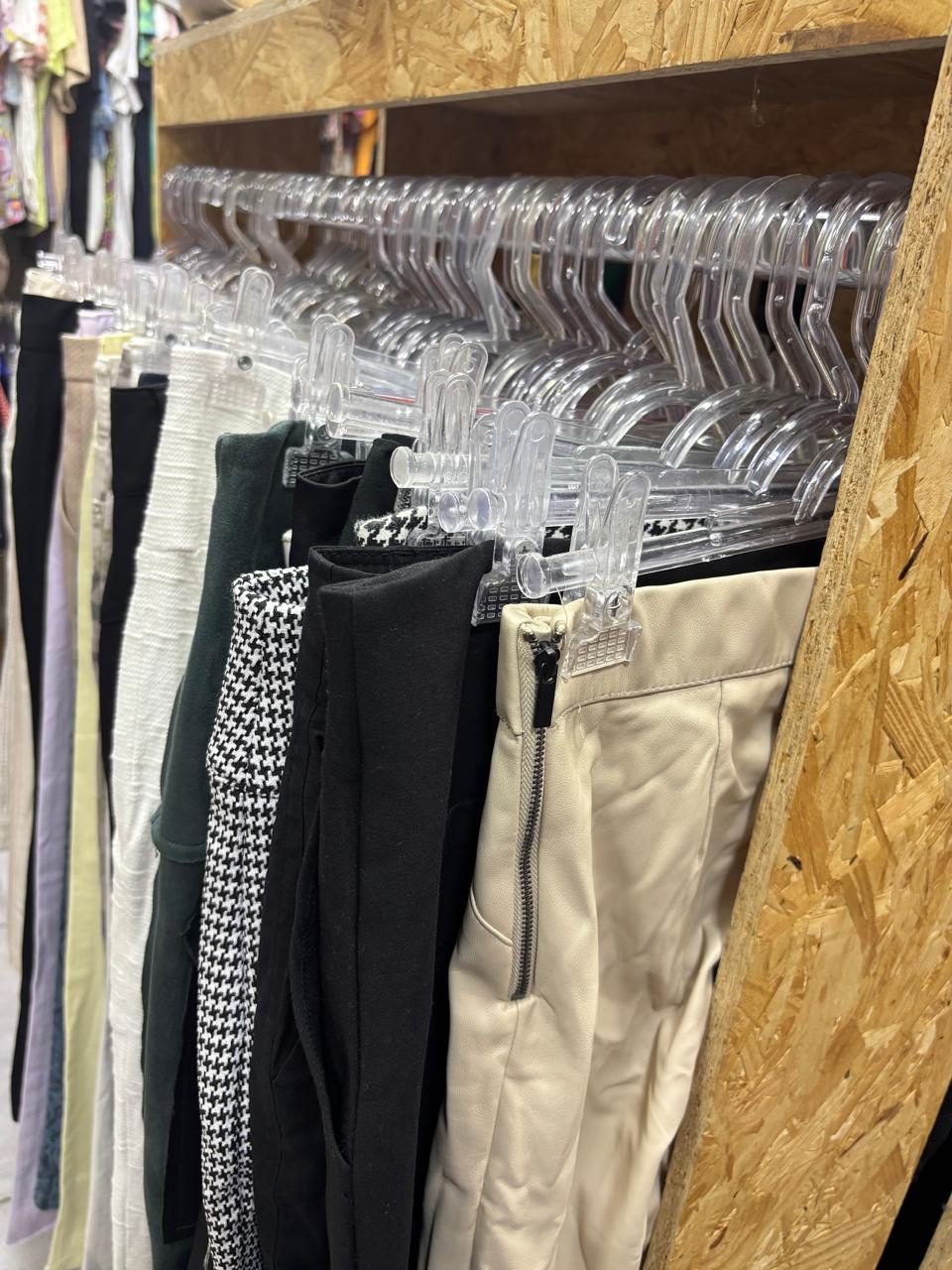 Interior do brechó Vénara com araras de peças selecionadas