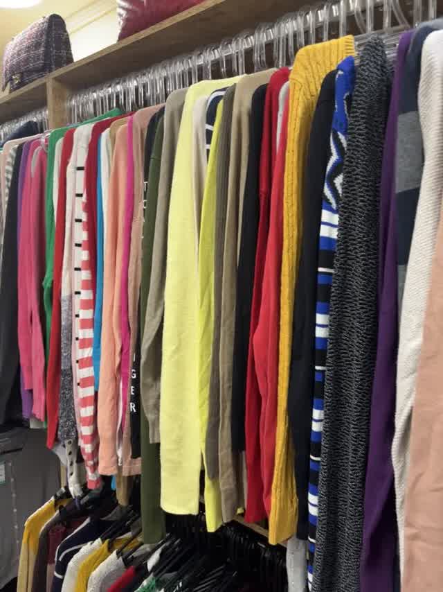 Arara com tricôs coloridos e bolsas na prateleira de cima